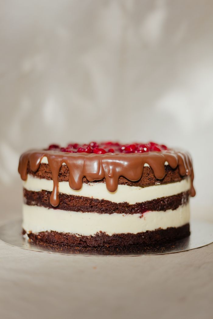 About Tantalizing chocolate drip cake with creamy layers and berry garnish, perfect for dessert lovers.