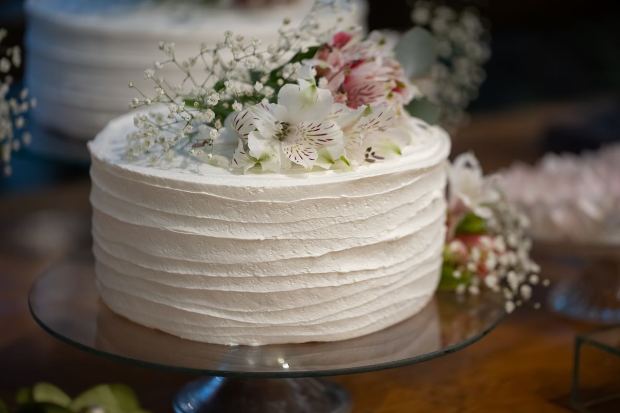 Services Beautiful white cake topped with flowers perfect for weddings and celebrations.